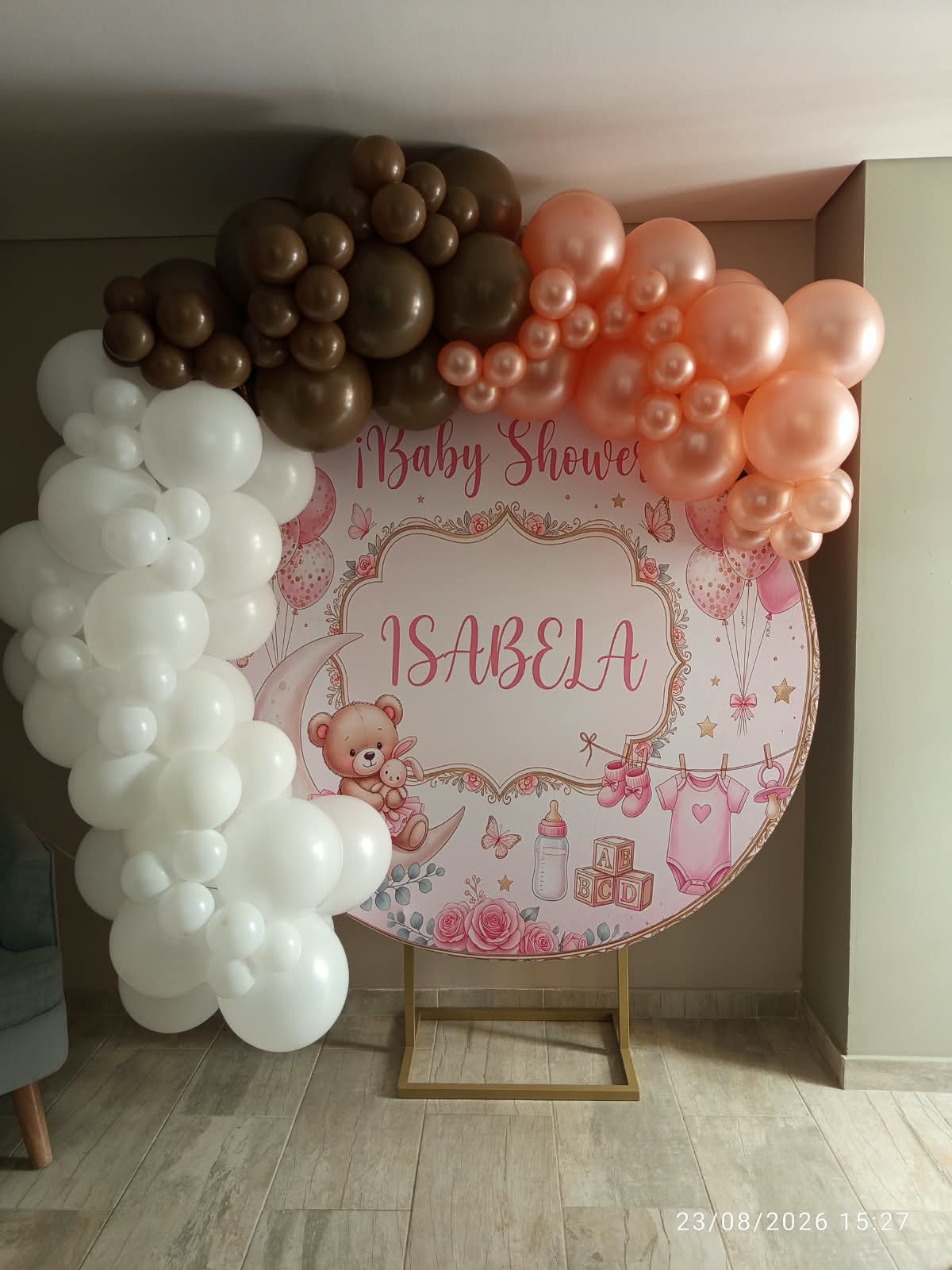Baby shower con globos café, durazno y blanco alrededor de un backdrop circular
