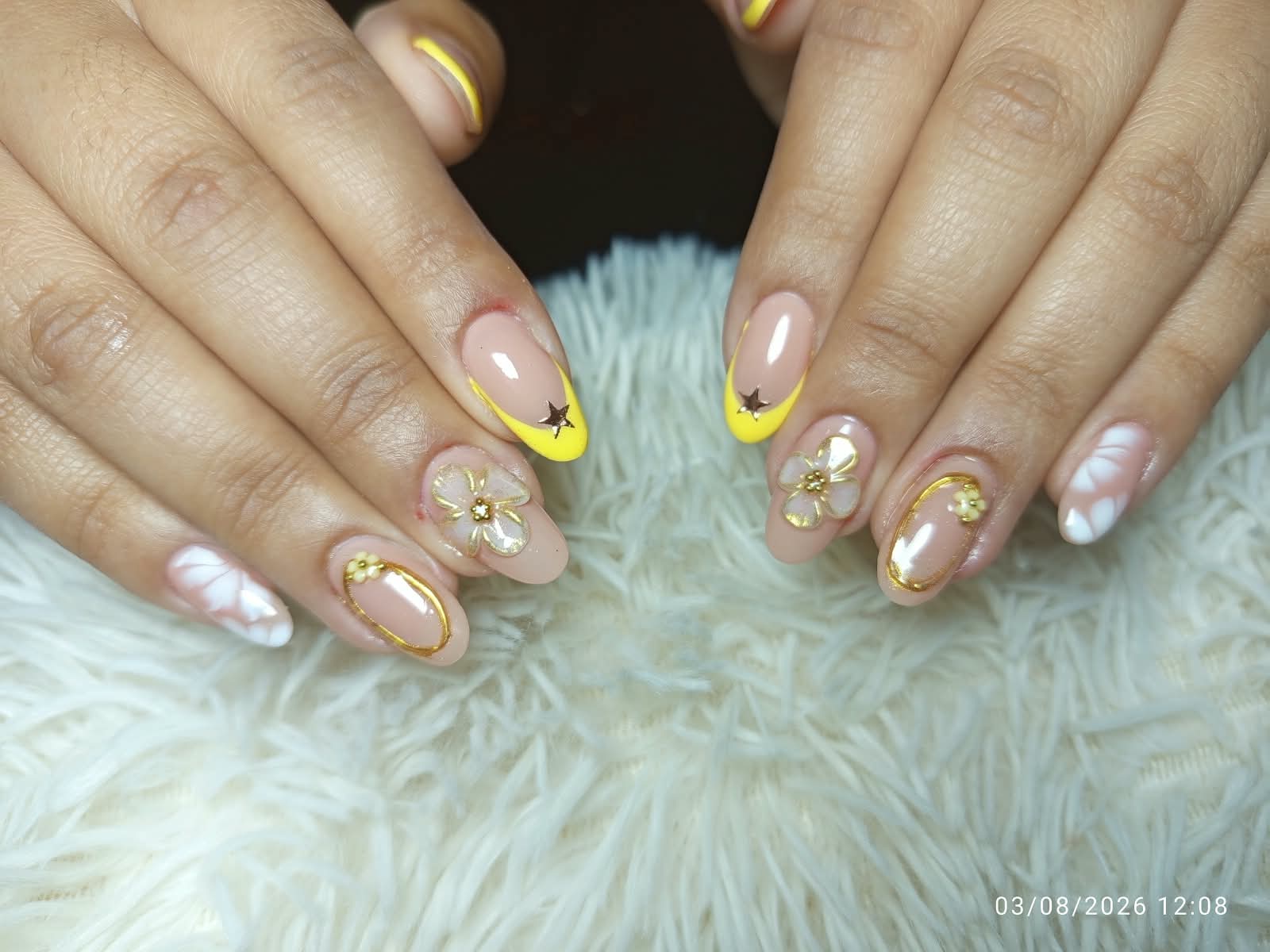Uñas nude con puntas amarillas, estrellas y flores doradas